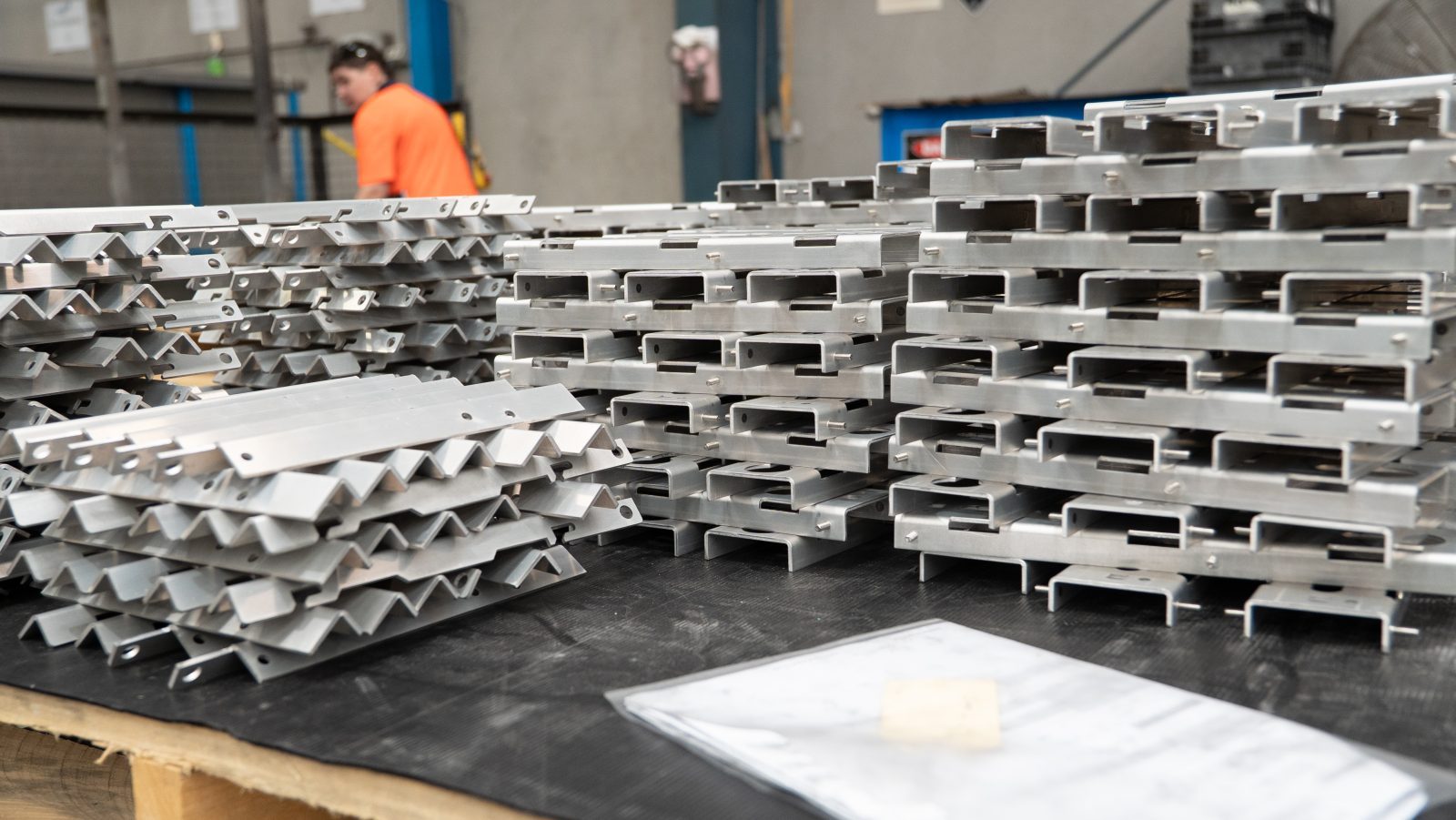 Operator stacking finished metal parts on a rack
