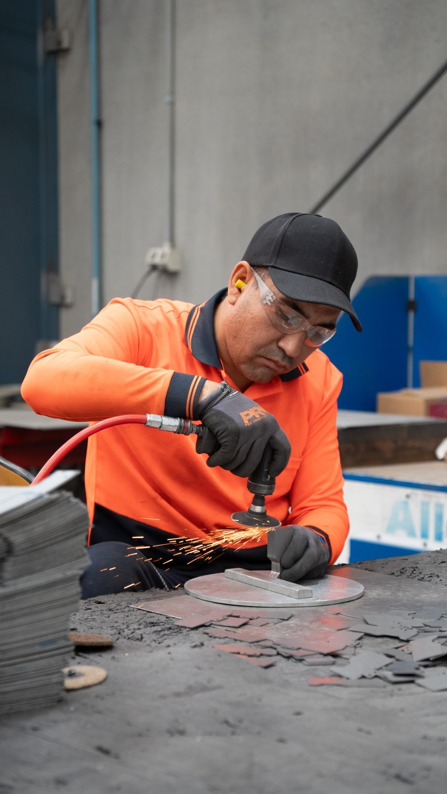 Operator finishing a metal part at the deburring station