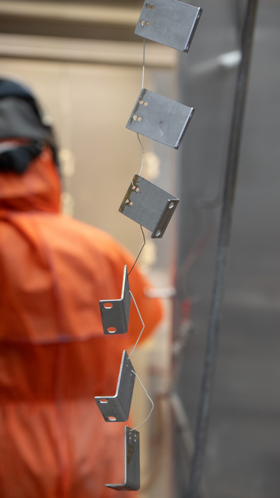 Powder-coated steel brackets hanging on the line