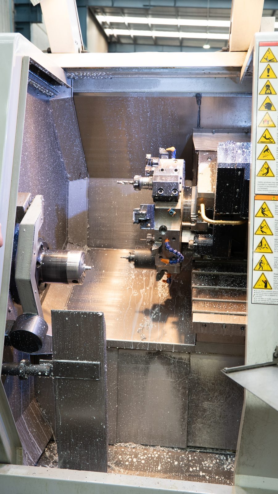 CNC lathe chuck and tooling cutting a turned component