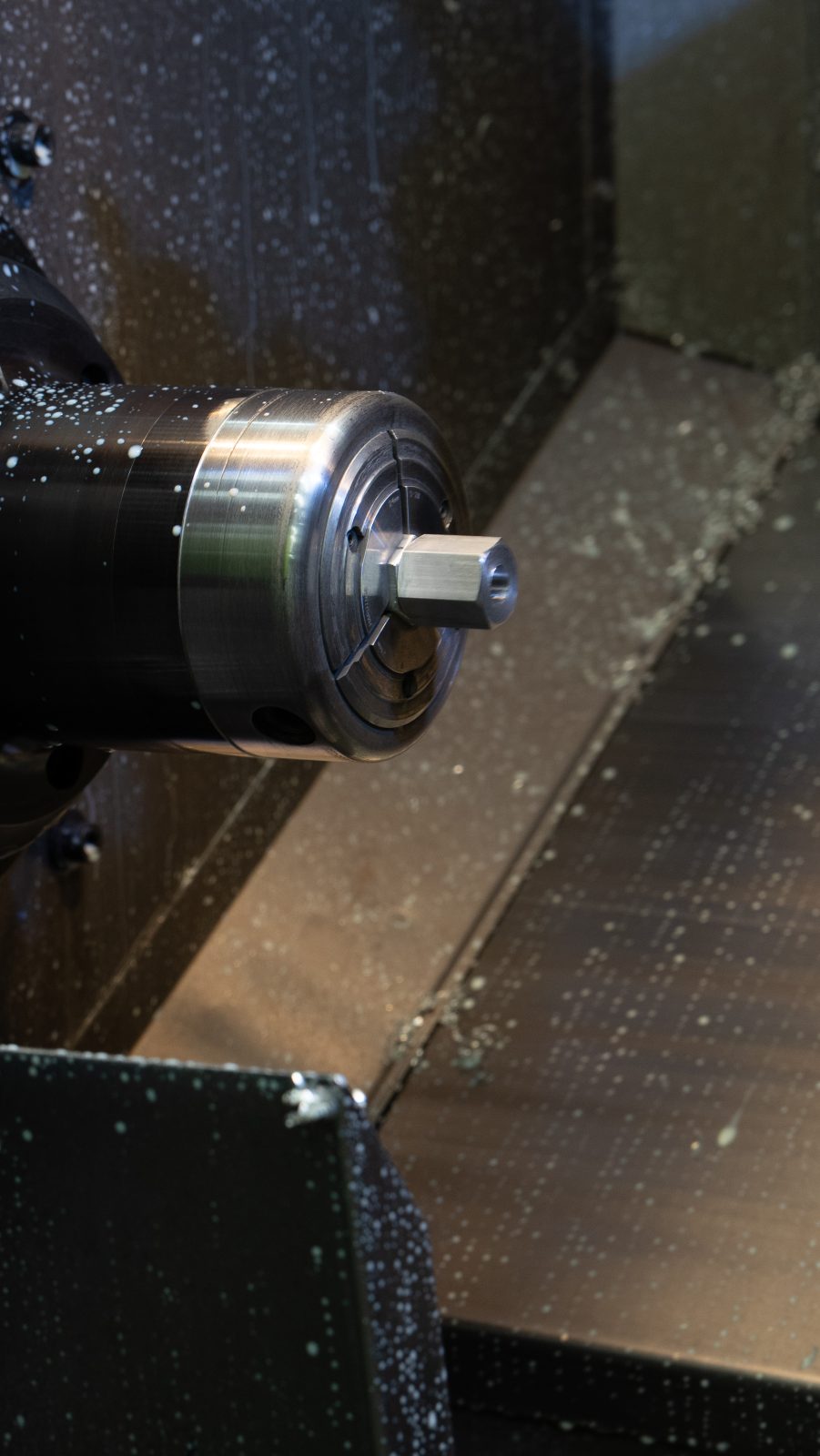 Close-up of a turned metal component on the CNC lathe spindle
