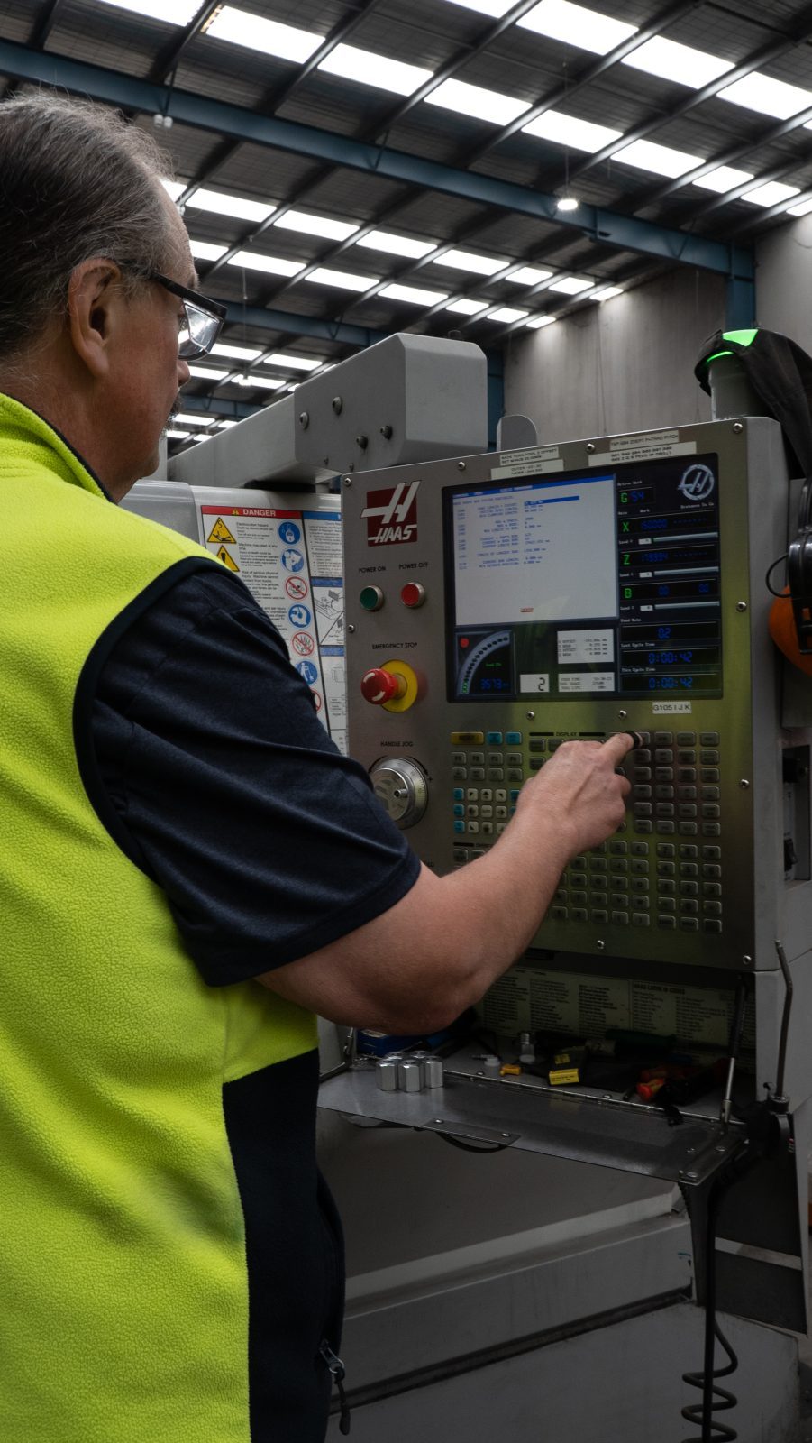 Operator at the Haas CNC machining centre controls