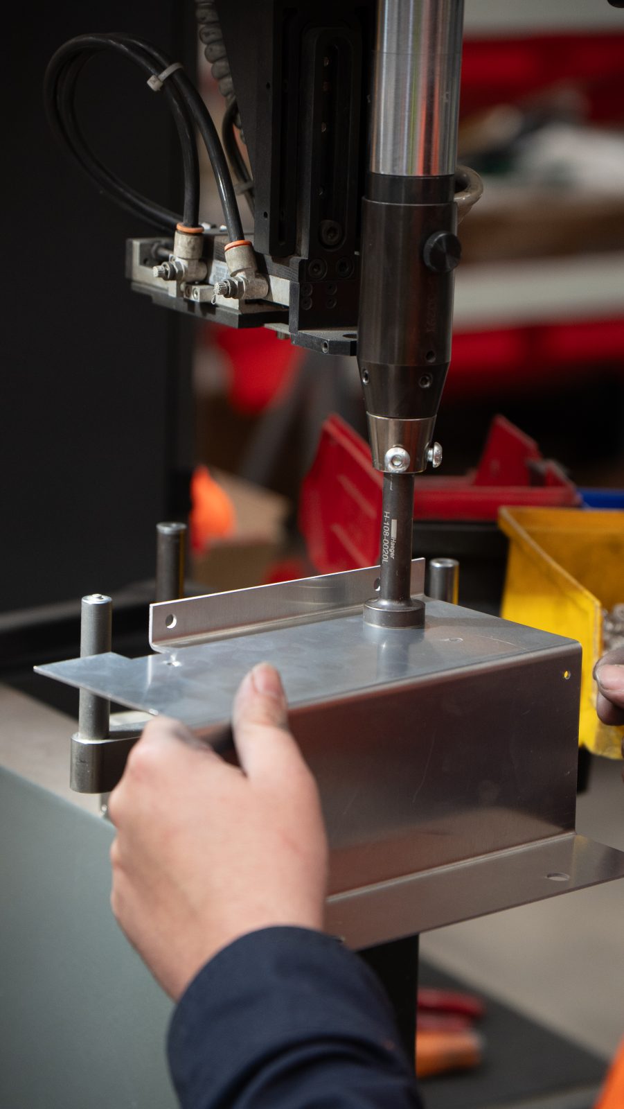 Haeger fastener insertion press fitting a clinch fastener into a sheet metal enclosure